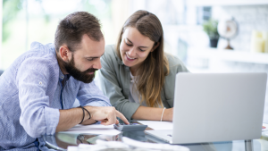 Couple analysant un budget avec un conseiller, illustrant l’assurance RC privée en Suisse
